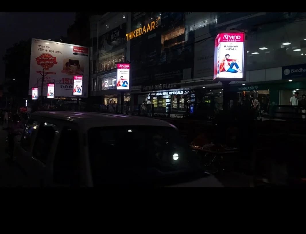 Row of illuminated pole kiosks lit up at night in Patna